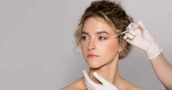 Woman receiving Botox injection near eye area for wrinkle reduction, performed by a medical professional wearing gloves in Henderson, NV