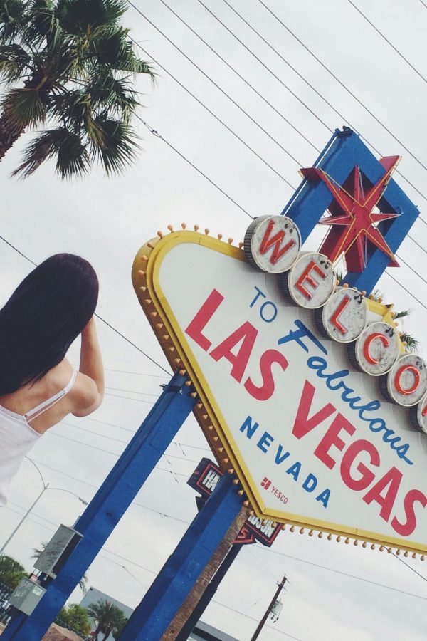 A girl standing in front of Welcome to fabulous Las Vegas sign, Las Vegas, Nevada, The USA